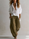 Completo con camicia bianca ampia e pantaloni a zampa verde oliva